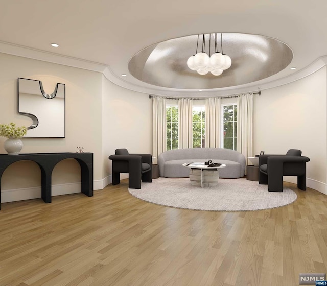 sitting room featuring hardwood / wood-style floors, a raised ceiling, and a chandelier