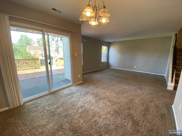 unfurnished living room featuring a chandelier, carpet floors, and a healthy amount of sunlight