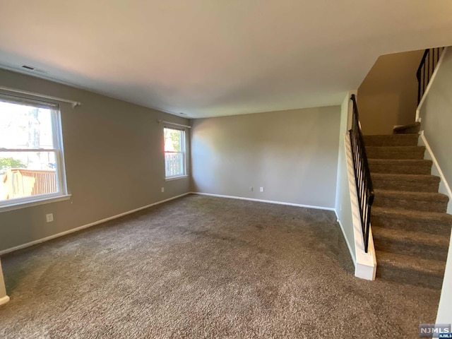 unfurnished room featuring dark carpet