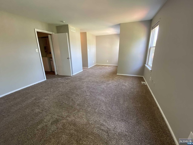 carpeted empty room featuring washer / clothes dryer