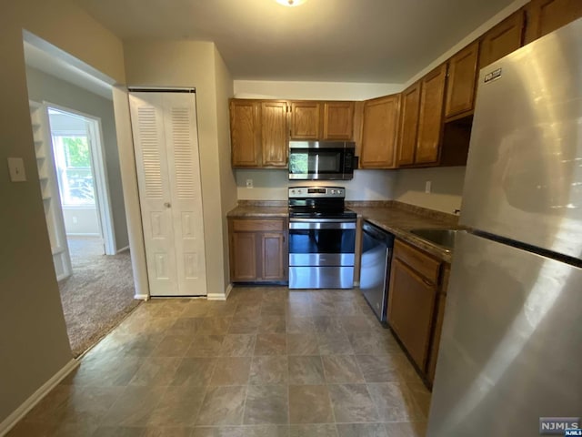 kitchen with carpet flooring and appliances with stainless steel finishes