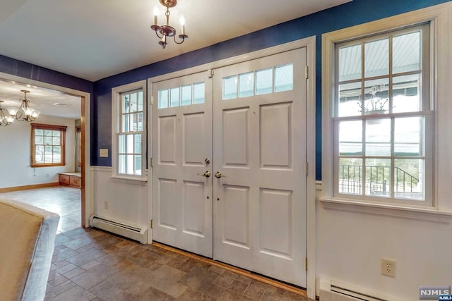 entrance foyer featuring a notable chandelier and a baseboard heating unit