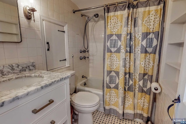 full bathroom featuring vanity, toilet, shower / bath combo, and tile walls