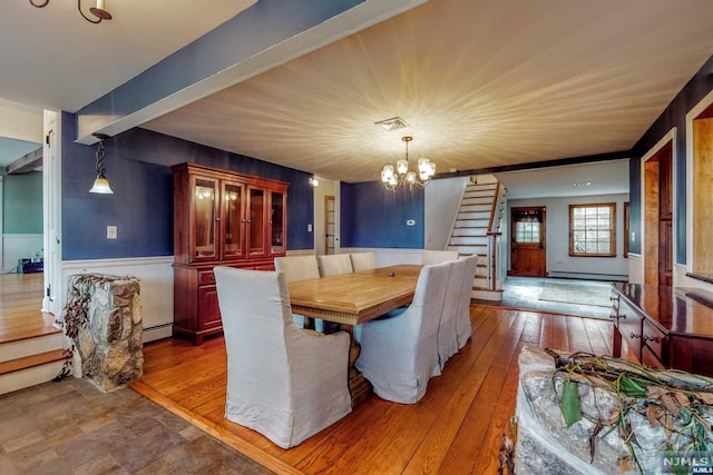 dining space with hardwood / wood-style flooring, baseboard heating, beamed ceiling, and an inviting chandelier