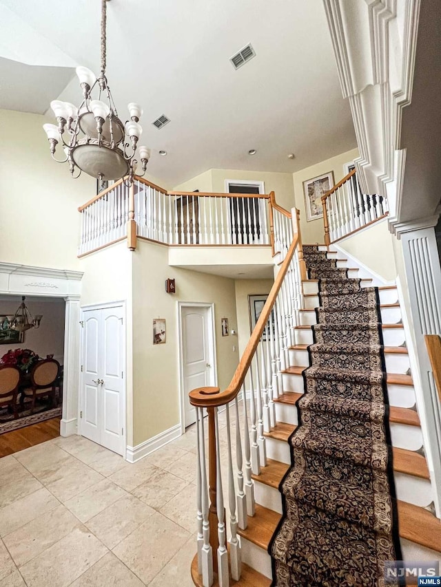 staircase featuring a chandelier and tile patterned flooring