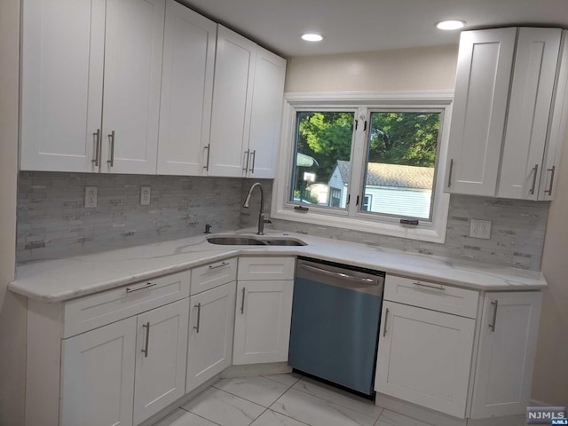 kitchen with tasteful backsplash, dishwasher, white cabinets, and sink