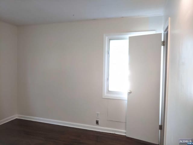 unfurnished room featuring dark hardwood / wood-style floors