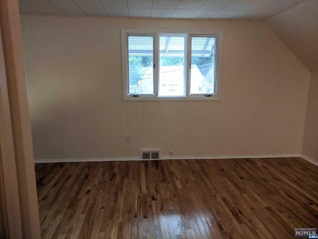 additional living space with dark hardwood / wood-style flooring and vaulted ceiling