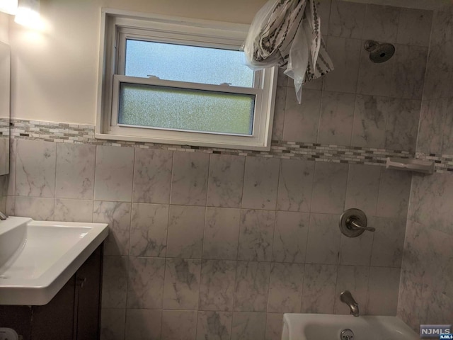 bathroom featuring vanity and tiled shower / bath