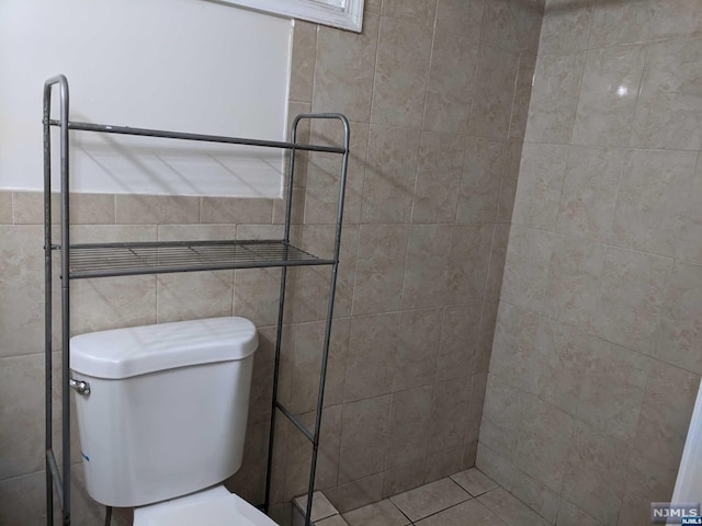 bathroom with toilet and tile walls