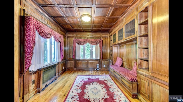 unfurnished room with built in shelves, wooden ceiling, coffered ceiling, light hardwood / wood-style floors, and wooden walls