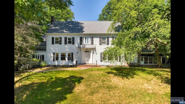 colonial-style house with a front lawn