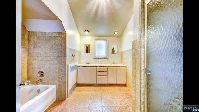 bathroom with vanity, tile walls, and independent shower and bath