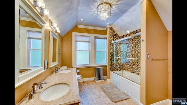 full bathroom featuring combined bath / shower with glass door, crown molding, hardwood / wood-style floors, radiator heating unit, and toilet