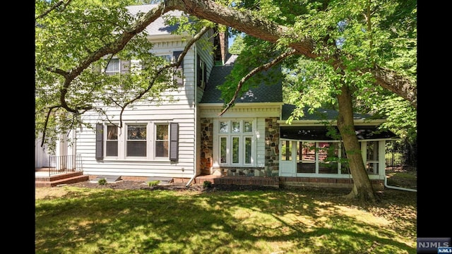 rear view of house featuring a yard