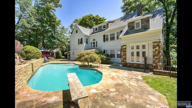 back of house with a fenced in pool and a patio