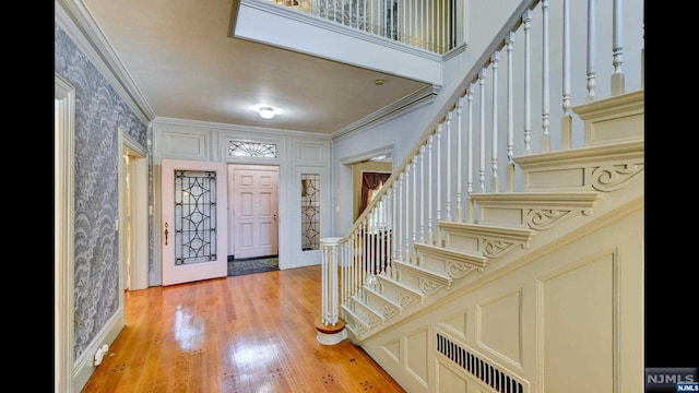 foyer featuring light hardwood / wood-style floors and crown molding