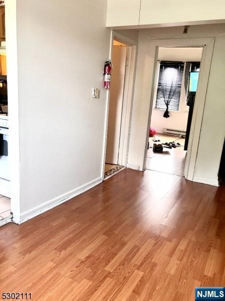 hallway featuring baseboard heating and hardwood / wood-style floors