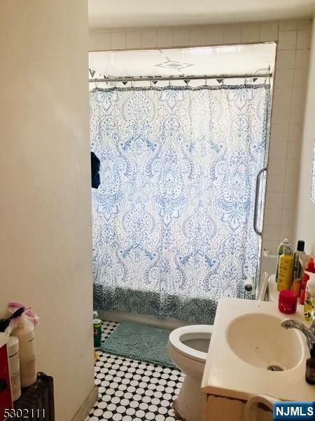 full bathroom with toilet, vanity, and shower / bathtub combination with curtain