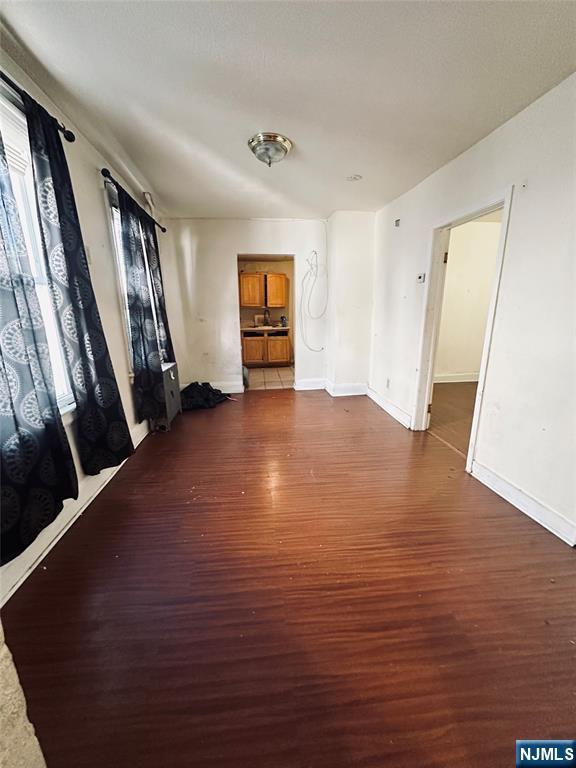 unfurnished living room with dark hardwood / wood-style flooring