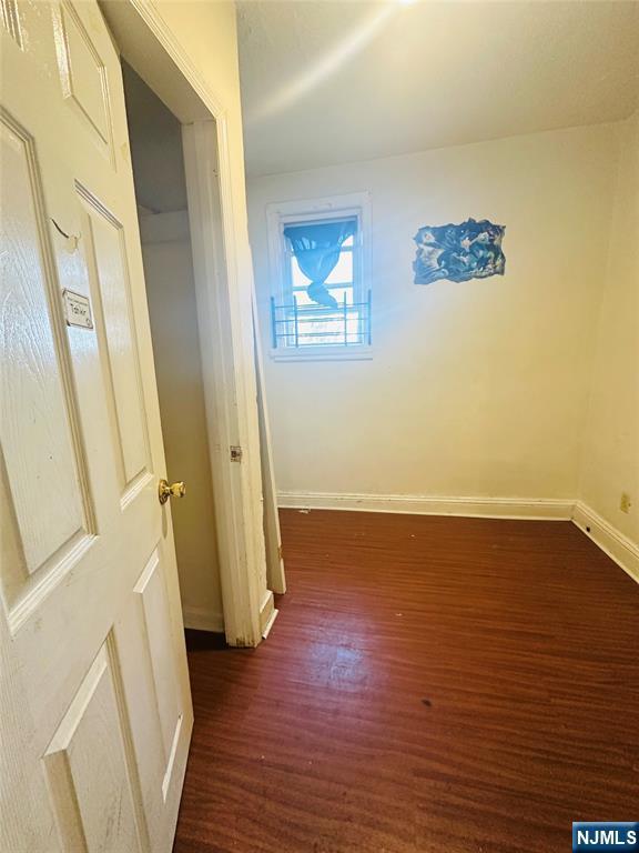 corridor with dark hardwood / wood-style flooring