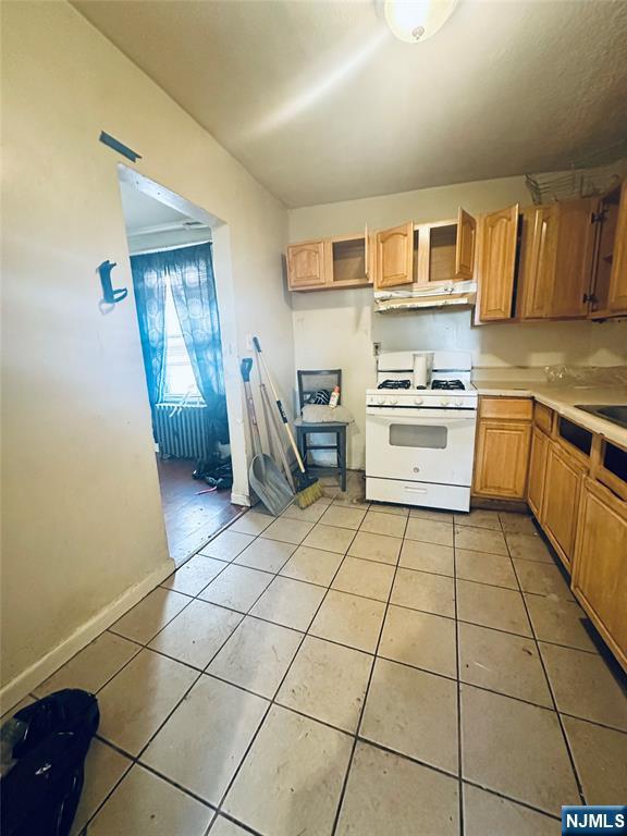 kitchen with light tile patterned floors and white gas stove