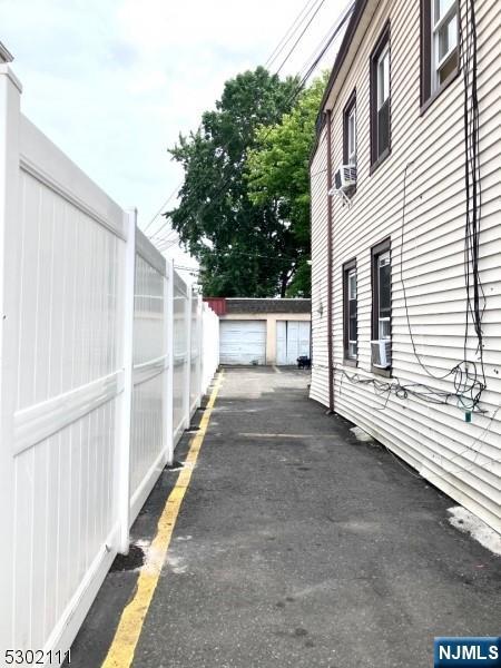 view of home's exterior with a garage, cooling unit, and an outdoor structure