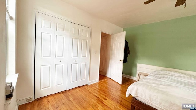 bedroom with a closet, light hardwood / wood-style flooring, and ceiling fan