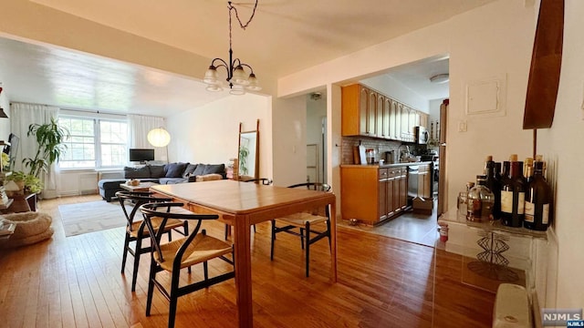 dining room with hardwood / wood-style flooring and a chandelier