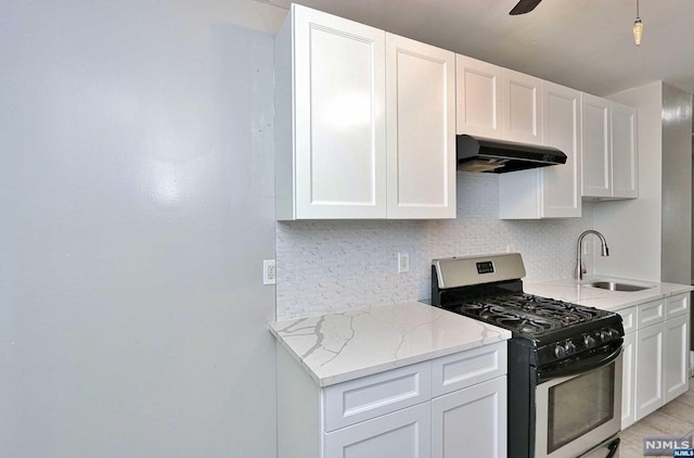 kitchen with white cabinetry, sink, extractor fan, and stainless steel gas range