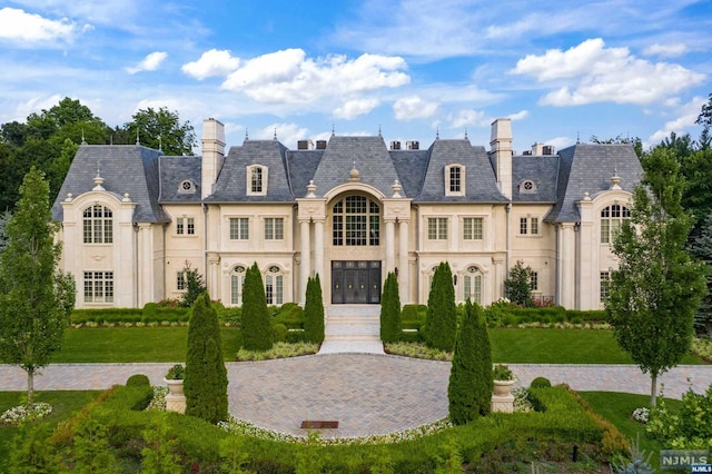 french country inspired facade featuring a front lawn