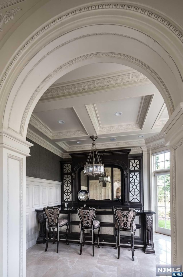 interior space featuring ornamental molding, an inviting chandelier, coffered ceiling, and beam ceiling