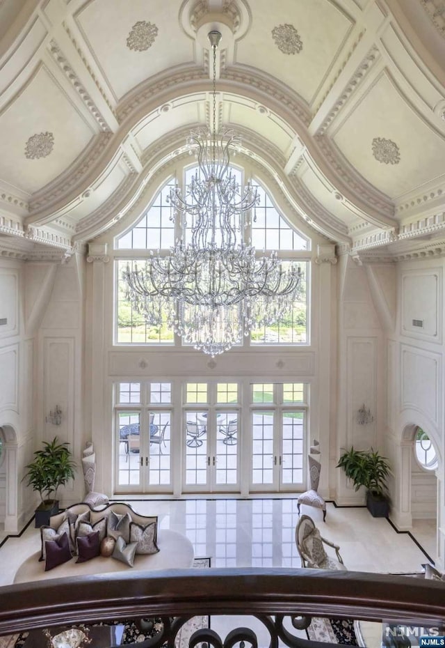 interior space with a chandelier, french doors, plenty of natural light, and a high ceiling