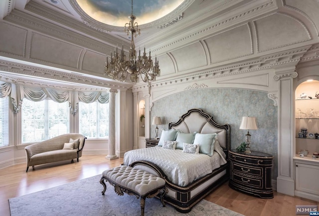 bedroom featuring ornate columns, ornamental molding, and light hardwood / wood-style flooring