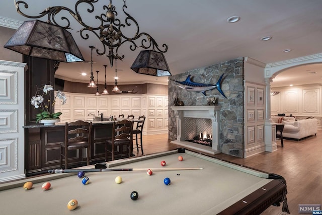 rec room with ornate columns, billiards, hardwood / wood-style floors, a fireplace, and ornamental molding