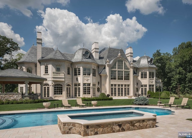 back of house with a gazebo, a patio area, and a swimming pool with hot tub