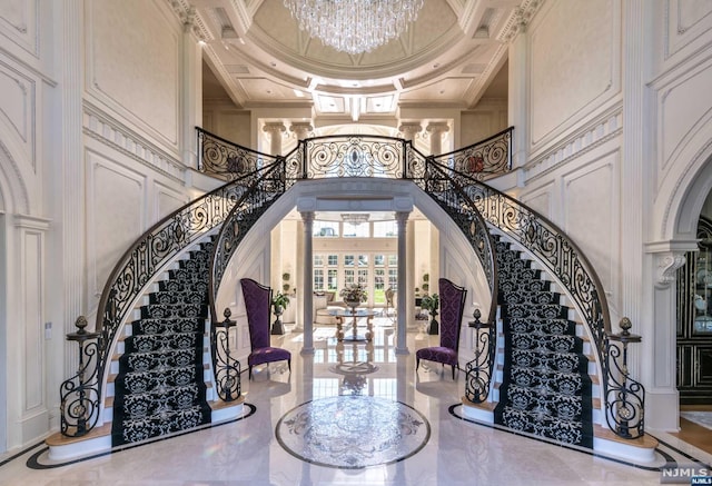 entrance foyer featuring ornate columns, a towering ceiling, coffered ceiling, and ornamental molding