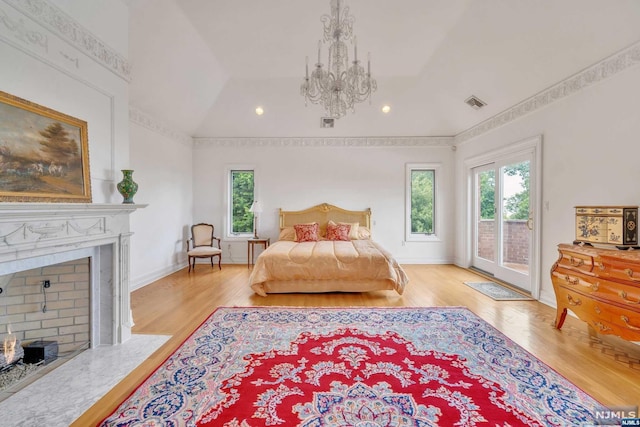 bedroom featuring access to exterior, light hardwood / wood-style flooring, and lofted ceiling