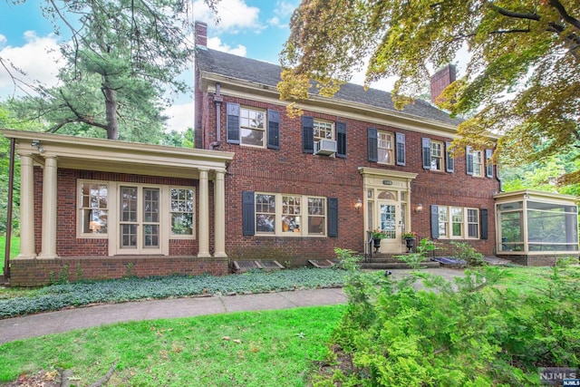 colonial house with cooling unit and a sunroom