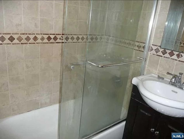 bathroom with vanity and tile walls