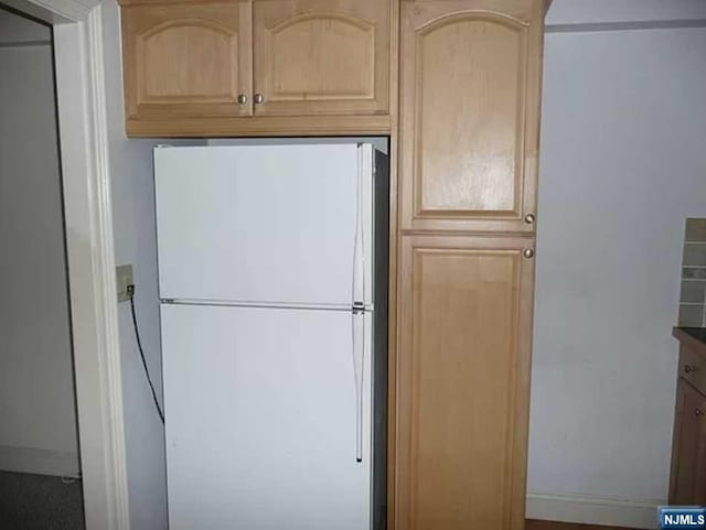 kitchen with white fridge and light brown cabinets