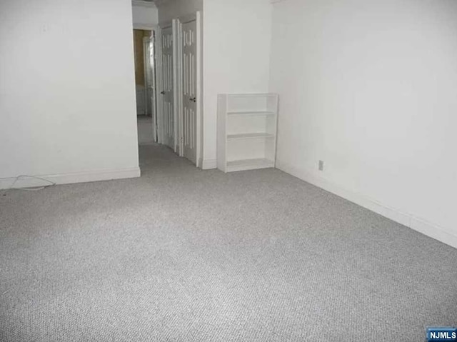 spare room featuring light carpet