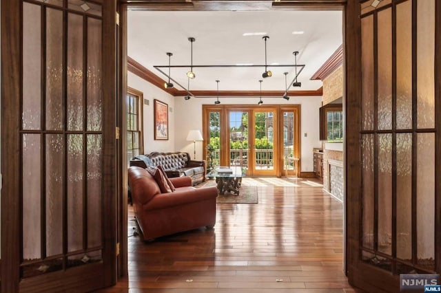 living room with hardwood / wood-style flooring, ornamental molding, and french doors