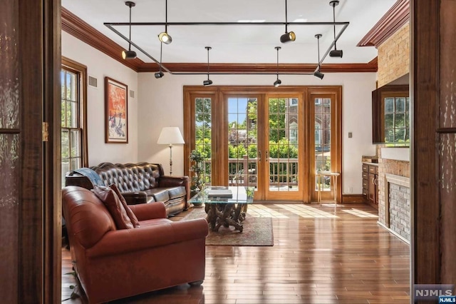 living room with hardwood / wood-style floors, ornamental molding, and french doors