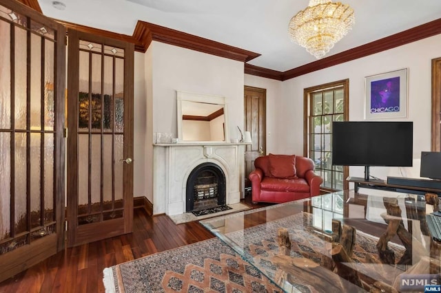 living room with ornamental molding, dark wood-type flooring, and an inviting chandelier