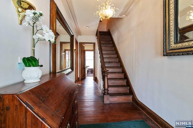 staircase featuring crown molding, hardwood / wood-style floors, and an inviting chandelier