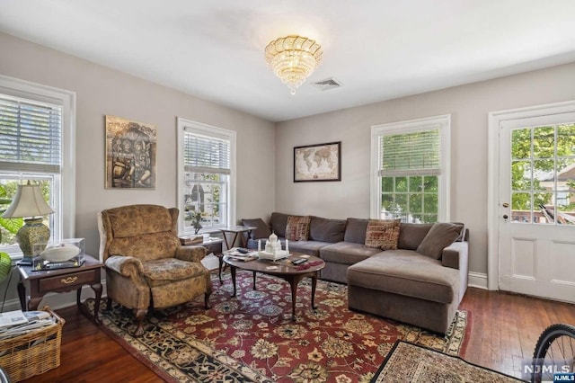 living room with dark hardwood / wood-style floors and a notable chandelier