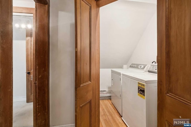 laundry area with light wood-type flooring and washer and clothes dryer