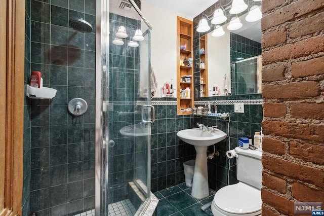 bathroom featuring tile patterned floors, toilet, tile walls, and walk in shower