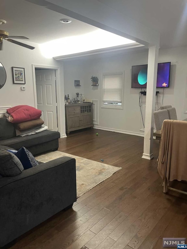 living room featuring ceiling fan and dark hardwood / wood-style flooring